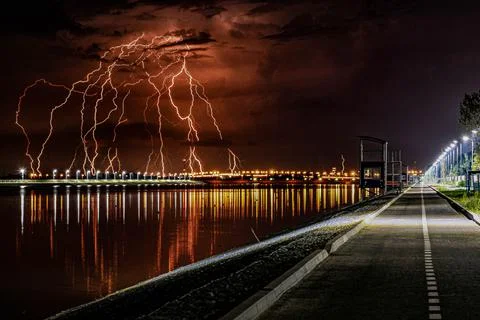 Dangerous lightning strike and flashes with rain clouds over night city Stock Photos