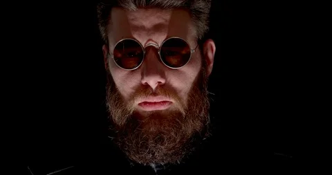 Dangerous man with beard with lights changing on his face Stock Footage 104286903