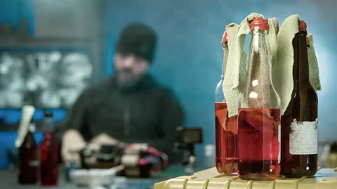 Dangerous man checks the weapon. At the forefront of the bottle molotov cocktail Stock Footage 99767528