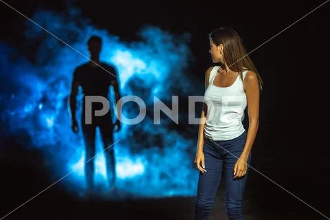The dangerous man in smoke following the woman in the dark street Stock Photos