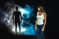 The dangerous man in smoke following the woman in the dark street Photo