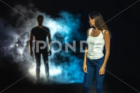 The dangerous man in smoke following the woman in the dark street Stock Photos
