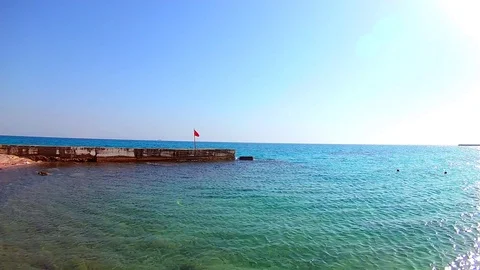 Dangerous red flag on a pier on the Red Sea, Egypt. Sunny windy day, wide angle Stock Footage 114656860