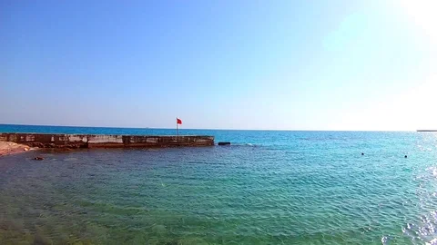 Dangerous red flag on a pier on the Red Sea, Egypt. Sunny windy day, wide angle. Stock Footage 114801702
