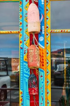 Dangling wind chime or bell decor with vibrant wall mural behind clay creations Foto stock