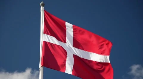 A Danish flag flutters in the wind against a blue sky background Stock Footage 65730855