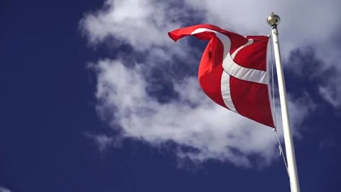 Danish flag isolated on the blue sky with clouds in slow motion. Close up of Stock Footage 221317576