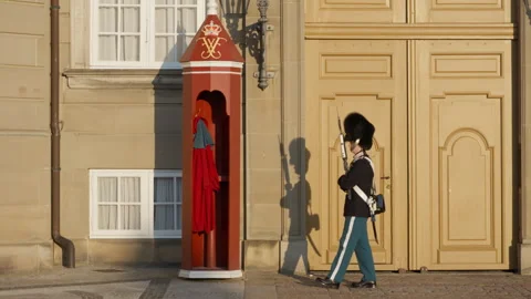 Danish Royal Life Guard marching past a red sentry box at Amalienborg Palace Stock Footage 345037271