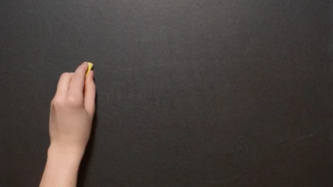 Danke. A left female hand writes the word Danke by yellow chalk on a black board Stock Footage 127291372