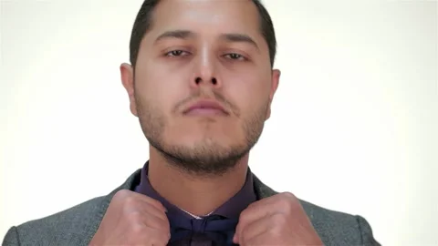Dapper man adjusting his bow tie with confidence Stock Footage 311539415