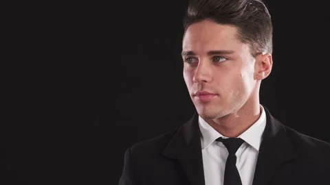 A dapper young man in a suit gazes thoughtfully into the distance Stock Footage 311991948