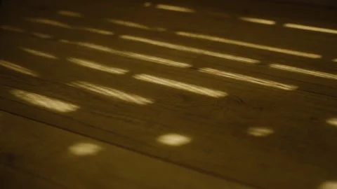 Dappled light shining through window blinds or shutters on wooden floor Stock Footage 316317482