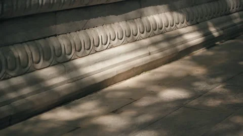 Dappled Sunlight Shadows on Textured Stone Wall with Carvings Vidéo 337417591