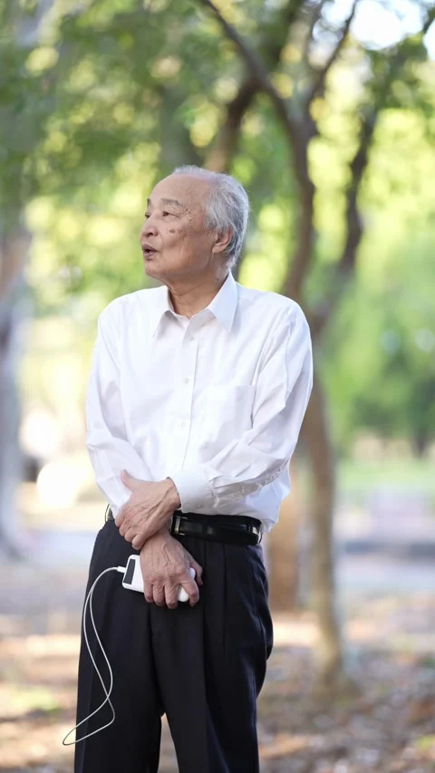 In the dappled sunlight of a spring natural park, a Japanese businessman in his Stock Footage 307889286