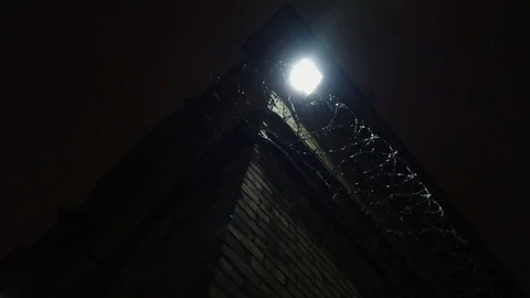 Dark abandoned prison yard, sharp fences visible at night, the outside Stock Footage 121864206
