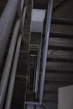 Dark Abstract Diagonal View Down Concrete Stairwell with Metal Handrails Foto stock
