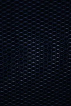 Dark abstract macro background of black metallic honeycomb mesh Stock Photos