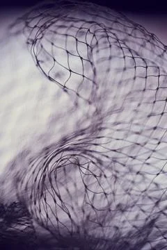 Dark abstract macro of tangled nylon mesh with moody purple lighting. Intri.. Stock Photos