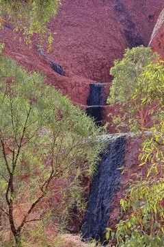 Dark algae-marked falling watermark in Uluru seen from the base walk. NT-AUS Stock Photos