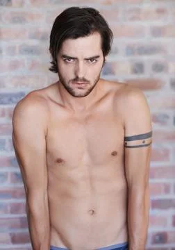 Dark and brooding. Portrait of a handsome shirtless man looking serious with a Fotos de archivo