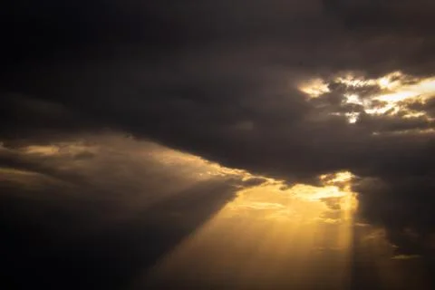 Dark and cloudy sky with a ray of light Stock Photos