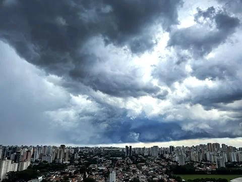 Dark and dramatic rain clouds over a city. Stock Photos