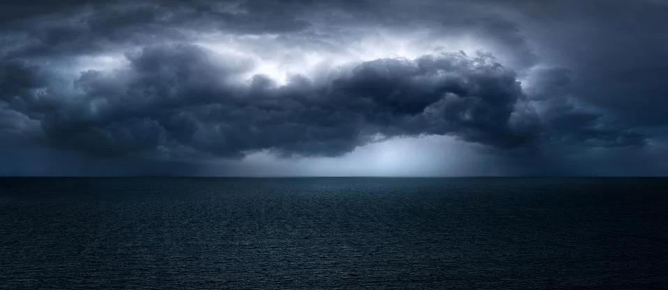 Dark and dramatic stormy clouds over sea Stock Photos