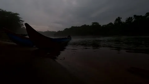 Dark and gritty view of a tropical river with canoes in front of the river Video stock 336913018
