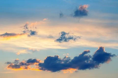 Dark and light clouds blend together in a stunning sunset sky. The sun's go.. Stock Photos