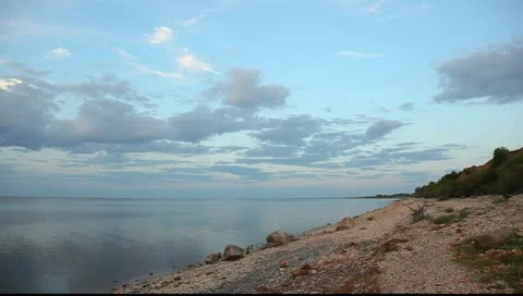 Dark and white clouds and lake surface, pan shot, evening, sunset Vídeo Stock 10892165