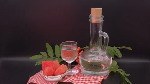 On a dark background. A decanter, a stack of vodka and pieces of watermelon. Stock Footage 114070881