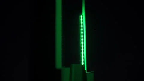 A dark background with a green object in the foreground Stock Footage 296093622
