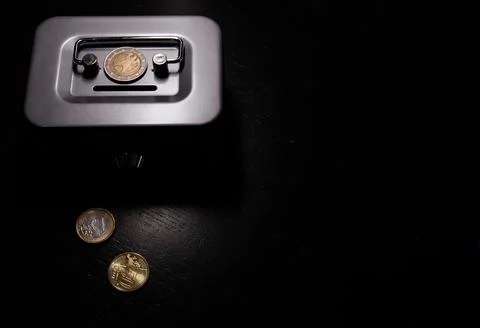 Dark background highlights metallic scale with coin Fotos Stock