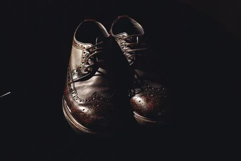 Dark background highlights polished leather shoes Foto stock