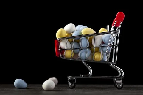 Dark background image with a toy shopping cart filled with crisp sugar coated Stock Photos