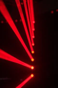 Dark background with intense, web-like red laser patterns radiating outward. Foto stock
