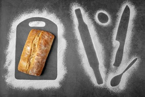 Dark background with loaf of bread and flour contours of some things for ba.. Stock-Fotos