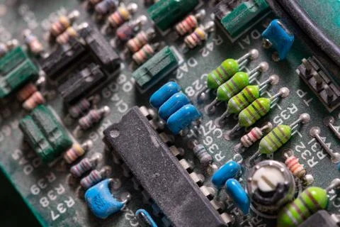Dark background of old electronic circuit board closeup with dus Фото