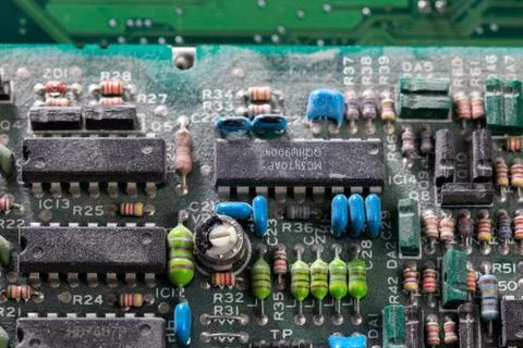 Dark background of old electronic circuit board closeup with dus Photos