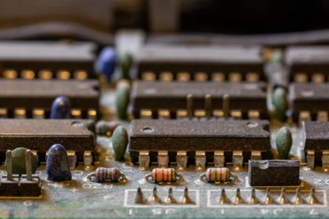 Dark background of old electronic circuit board closeup with dus Photos