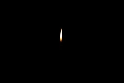 On a dark background only a candle flame Stock Photos