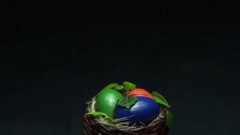 On a dark background revolves wicker basket with Easter eggs Stock Footage 73015409
