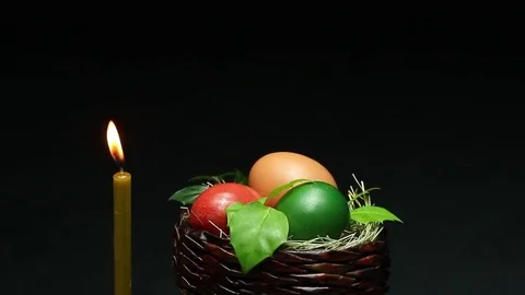 On a dark background revolves wicker basket with Easter eggs Stock Footage 73015444