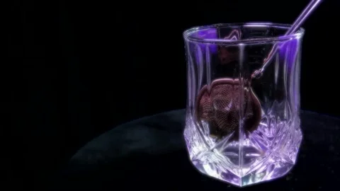 On a dark background tea is brewed in a glass cup. Stock Footage 154552534