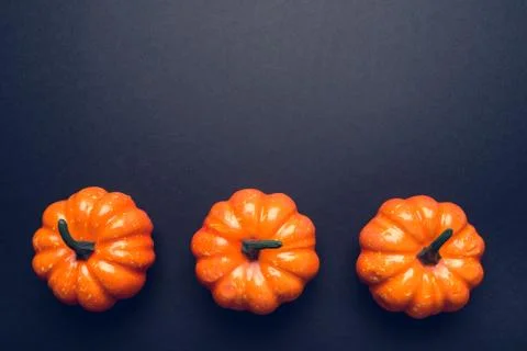 Dark background with three pumpkins. Stock Photos