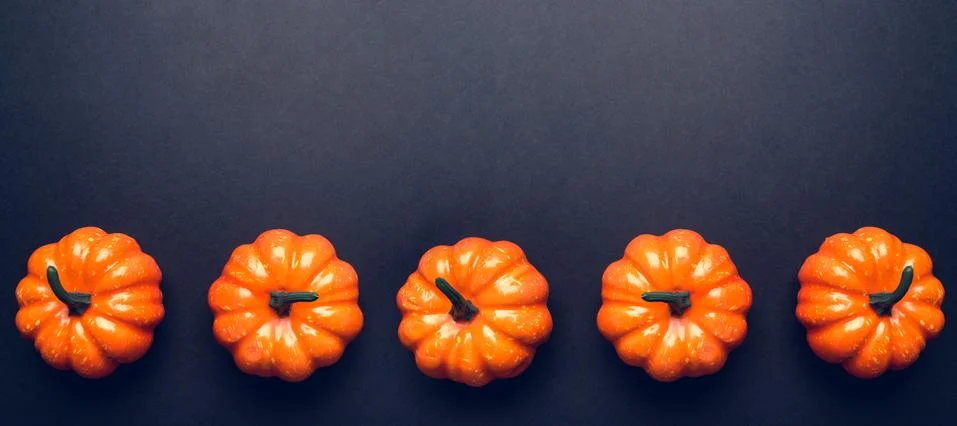 Dark background with three pumpkins. Stock Photos