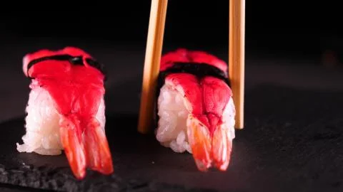 On a dark background on a tray, cooked or purchased sushi (Nigiri) Stock Photos