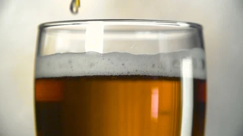 Dark beer is poured into a glass. Slow motion of bubbles in beer. Vídeos de archivo 84042053