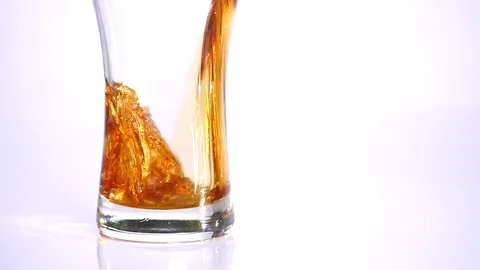 Dark Beer is pouring into glass on white background. close up Stock Footage