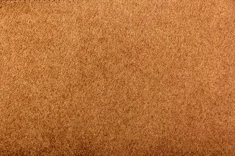 Dark beige matte background of suede fabric, closeup. Beige suede soft leather Stock Photos